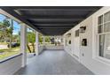 Covered porch with gray tile flooring, stylish lighting, and white craftsman style posts at 314 E Harwood St, Orlando, FL 32801