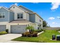 Beautiful townhome with attached garage, complemented by lush landscaping and vibrant greenery at 3600 Plainview Dr, Orlando, FL 32824