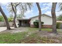 Inviting home featuring brick accents, a screened front porch, and a well-manicured lawn with mature trees at 407 Ventura Dr, Sanford, FL 32773