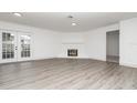 Bright living room featuring new flooring, fireplace, modern lighting, and French doors to the backyard at 407 Ventura Dr, Sanford, FL 32773