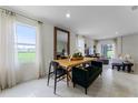 Open dining area with a large window, modern table setting, and seamless flow to the living space at 6006 Galloping Dr, Apopka, FL 32712