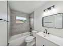 Modern bathroom features a sleek vanity, updated lighting, and a shower-tub combo for relaxation at 772 Whippoorwill Dr, Orlando, FL 32825