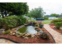 Beautiful water feature with pond, plants, and decorative rocks in the front yard at 8718 Fort Shea Ave, Orlando, FL 32822