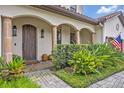 Inviting covered front porch with stone columns, wooden front door, and manicured landscaping at 922 N Pennsylvania Ave, Winter Park, FL 32789