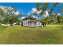 Exterior view of home on expansive lot featuring mature trees and a partially covered porch at 9329 7Th Ave, Orlando, FL 32824