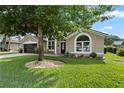 Charming home featuring arched windows, a two-car garage, and a well-maintained front yard with landscaping at 1008 Soldier Creek Ct, Oviedo, FL 32765