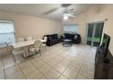 Open-concept living room with ceramic tile floors, comfortable seating, and sliding glass door to the patio at 11236 Rouse Run Cir, Orlando, FL 32817
