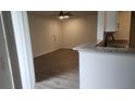 Open concept living room adjacent to kitchen with updated flooring and view to front door at 11588 Westwood Blvd # 1523, Orlando, FL 32821