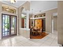 Inviting home foyer leads to the dining room, showcasing hardwood floors and large windows at 13626 Sunset Lakes Cir, Winter Garden, FL 34787
