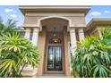 Elegant home entrance featuring stately columns and a decorative glass front door at 13626 Sunset Lakes Cir, Winter Garden, FL 34787