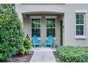 Inviting front porch with blue Adirondack chairs offers a cozy spot to enjoy the outdoors at 1391 Shinnecock Hills Dr, Davenport, FL 33896