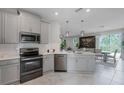 Modern kitchen features stainless steel appliances, ample counter space, and stylish gray cabinets at 1391 Shinnecock Hills Dr, Davenport, FL 33896