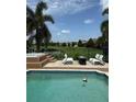 Backyard view of the in-ground pool, patio lounge chairs, and a jacuzzi with views of the water at 14744 Spotted Sandpiper Blvd, Winter Garden, FL 34787