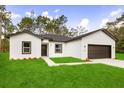 Charming single-story home featuring a well-manicured lawn and a two-car garage at 17465 Sw 41St Cir, Ocala, FL 34473