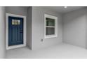 Close up of the entrance and sidelight window of the single story home with a blue front door at 17501 Sw 41St Cir, Ocala, FL 34473