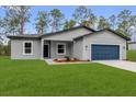 Charming single-story home with a blue garage door and freshly manicured front lawn at 17501 Sw 41St Cir, Ocala, FL 34473