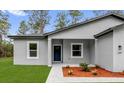 Close up of the entrance of the single story home with neat landscaping and a blue front door at 17501 Sw 41St Cir, Ocala, FL 34473
