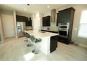 Modern kitchen features a large center island, sleek cabinetry, and stainless steel appliances at 2035 White Feather Loop, Oakland, FL 34787