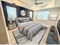 Stylishly furnished main bedroom featuring a textured accent wall and modern décor at 2035 White Feather Loop, Oakland, FL 34787