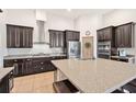Modern kitchen featuring granite countertops, stainless steel appliances, dark cabinetry and a spacious island at 2051 Sandy Garden Ln, Winter Garden, FL 34787