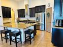 Modern kitchen featuring a large island with bar seating, stainless steel appliances, and sleek, dark cabinetry at 2051 Sandy Garden Ln, Winter Garden, FL 34787