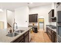 Open concept kitchen with granite counters, stainless steel appliances, tile floors, and modern fixtures at 2051 Sandy Garden Ln, Winter Garden, FL 34787