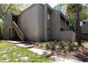 Inviting condo exterior with well-kept landscaping and stairs leading to the upper level at 211 Crown Oaks Way # 205, Longwood, FL 32779