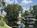 Scenic backyard view with a covered boat dock and lush trees reflected in the tranquil water at 213 N Monterey Isle, Longwood, FL 32779