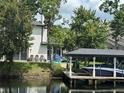 Backyard scene featuring a screened lanai, boat dock with boat lift, and waterfront access at 213 N Monterey Isle, Longwood, FL 32779