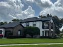 Stately home featuring a brick facade, a second-story balcony, and a well-maintained lawn with mature trees at 213 N Monterey Isle, Longwood, FL 32779