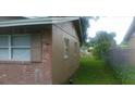A view of the side of the house showcases the fenced backyard, with plenty of room for outdoor activities at 2260 Willie Mays Pkwy, Orlando, FL 32811