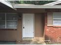 The home's front entrance is marked with a white door, flanked by windows and classic red brick at 2260 Willie Mays Pkwy, Orlando, FL 32811