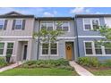 Inviting two-story townhome featuring a cute wreath on the door and manicured front garden at 3028 Water Sprite St, Orlando, FL 32808
