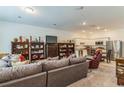 Open-concept living area boasts a comfortable sofa and seamless connection to the modern kitchen at 3028 Water Sprite St, Orlando, FL 32808