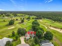Stunning aerial view of a home nestled on a lush golf course, surrounded by mature trees at 36730 Oconee Ave, Eustis, FL 32736