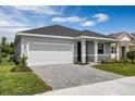 Charming single-story home with a manicured lawn and paved driveway leading to a two-car garage at 3756 Watercliff Cir, Grand Island, FL 32735