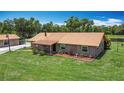 Exterior shot with a large lawn, well-maintained landscaping, and a metal roof at 4160 Packard Avenue, St Cloud, FL 34772