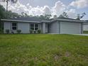 Well-manicured lawn and green shrubbery highlights the exterior of this single-story home at 4325 Sw 157Th Ter, Ocala, FL 34481
