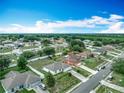 Expansive aerial view of a residential neighborhood with neatly arranged homes and green spaces at 5125 Pine Needle Dr, Mascotte, FL 34753