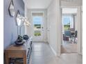 Bright entryway with tile flooring, complemented by modern decor, a glass-paneled front door, and a view of the office space at 5162 Masser Rd, St Cloud, FL 34772