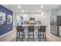 Modern kitchen featuring stainless steel appliances, a granite countertop island with seating, and white cabinetry at 5162 Masser Rd, St Cloud, FL 34772