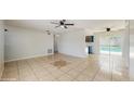 Open-concept living room with tile flooring leading to the kitchen and sliding glass doors at 624 American Heritage Pkwy, Orlando, FL 32809