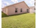 Spacious backyard with lush green lawn and a sliding glass door leading to the home's interior at 631 Lady Diana Dr, Davenport, FL 33837