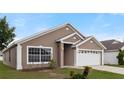 Charming single-story home with a well-maintained lawn and a two-car garage in a sunny neighborhood at 631 Lady Diana Dr, Davenport, FL 33837