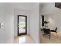 Bright entryway with modern door, travertine floors, leading to an adjacent dining area at 7145 Lake Dr, Orlando, FL 32809