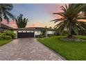 Charming single-story home features a paved driveway, a manicured lawn and mature palms at 7145 Lake Dr, Orlando, FL 32809
