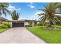 Charming single-story home features a paved driveway, a manicured lawn and mature palms at 7145 Lake Dr, Orlando, FL 32809
