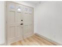 Bright foyer featuring neutral paint colors, wood-look floors, and a modern front door at 7446 Houston E Ct, Winter Park, FL 32792