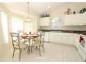 Sunny breakfast nook featuring a round glass table, stylish chairs, and white cabinetry at 8093 Indian Creek Blvd, Kissimmee, FL 34747