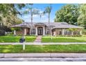 Beautiful home showcasing well-kept landscaping, a brick pathway, and a welcoming facade at 831 Royalwood Ln, Oviedo, FL 32765